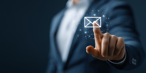 Digital Communication: An executive in a tailored suit reaches out to interact with a digital email icon, representing the modern era of instantaneous messaging and connectivity.