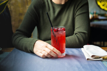 Cold lingonberry drink on restaurant table. Iced cowberry tea, refreshing cranberry cocktail © ange1011