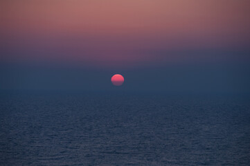 A beautiful sunset with a large red sun in the sky