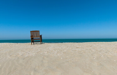 scenic view of a lonely wooden chair on the beach in winter
