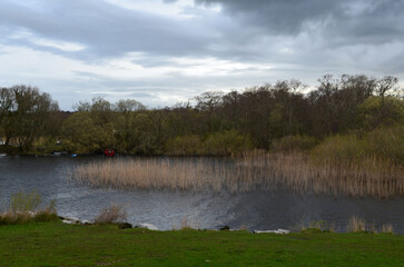 Fototapeta premium Dark Clouds Over a River with Boats Moored