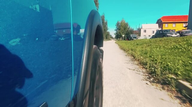 Camera on the car body. The car starts from a standstill and drives along the road.
