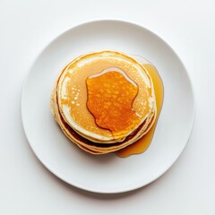 Overhead view of a stack of pancakes with syrup on a white round plate