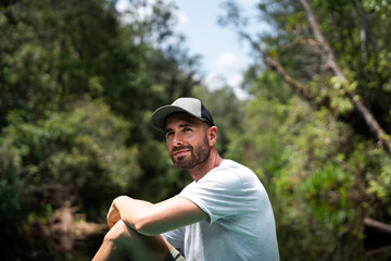 Handsome man tourist enjoying relaxing day in tropical forest river