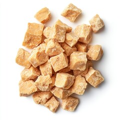 A scattered pile of jaggery cubes on a white surface, top down view