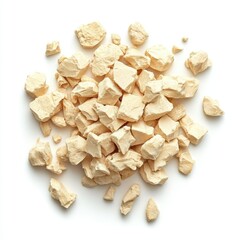A pile of irregularly shaped, light beige pieces on a white surface