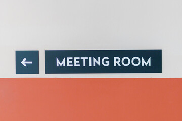 Sign directing to the meeting room with red and white design