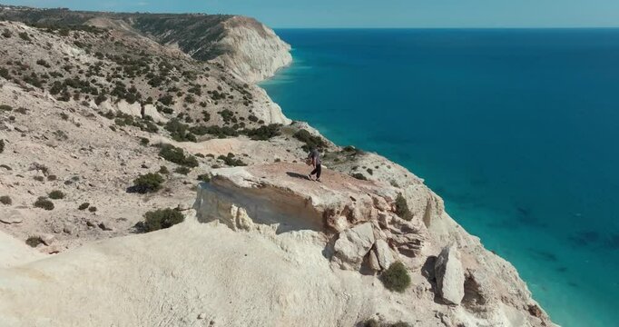 Aerial view of a man on top of a cliff near the Mediterranean Sea Cyprus. Expensive tourism and mountain hiking in the beautiful nature of the birch sea, a feeling of freedom. High quality 4k footage