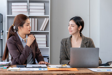 Two Businesswomen Discussing Work at Desk