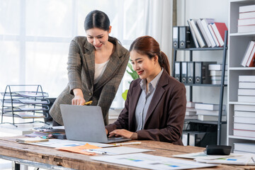 Two Businesswomen Collaborating on Laptop in Office