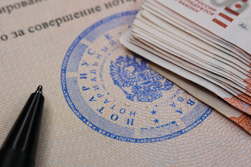 Macro Close Up Of A Blue Russian Notary Public Stamp On A Document, With Stack Of Ruble Banknotes...