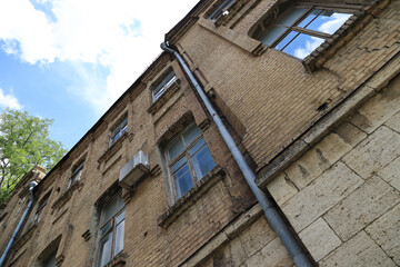 A View Of The Exterior Of A Brick Building With Several Windows And Metal Pipes.