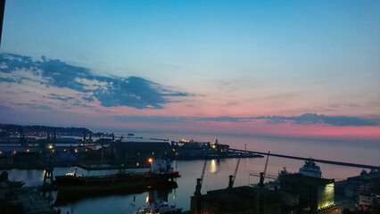 Harbor at sunset with vivid twilight sky and silhouettes of docked ships