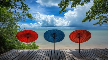 Three colorful parasols on a beach deck, facing the ocean.