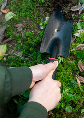 Child's hands holding gardening trowel