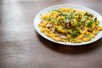 Italian pasta with creamy mushrooms and parsley on white plate in close-up