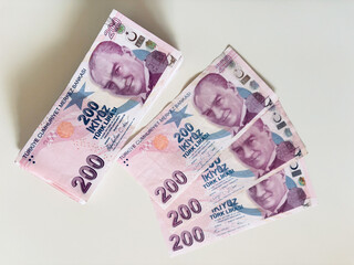 Turkish 200 Lira banknotes arranged on white background, emphasizing wealth and currency exchange