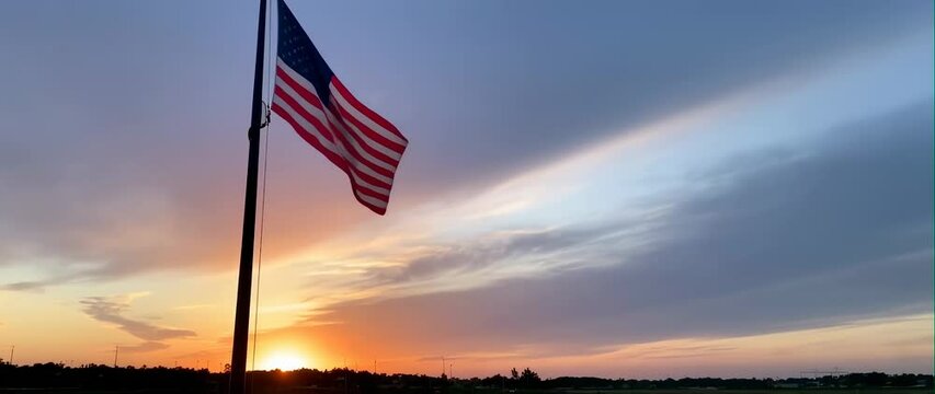Anamorphic video of The United States flag flutters in the sunrise