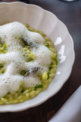 Creamy green risotto with foamy topping showcasing culinary innovation and artistry in modern cuisine concept