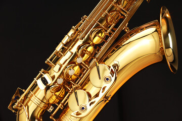 Obraz premium Jazz. One beautiful saxophone on black background, closeup