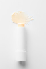 Stick of lip balm and sample on white background, top view