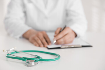 Fototapeta premium Doctor working and stethoscope on table in hospital, selective focus