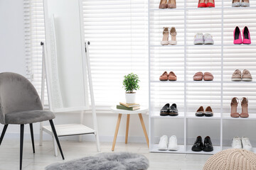 Shoe storage. Shelving unit with different footwear, accessories and mirror indoors