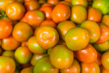 Tomatoes lying in a pile on top of each other, tomato texture.