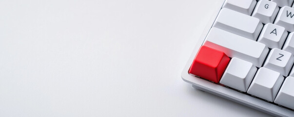 A close-up of a modern keyboard featuring a striking red key among white keys, set against a minimalistic background.