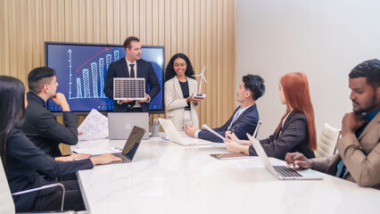 multiracial business people meeting,discussing and presentation with wind turbine and small solar panel in office room