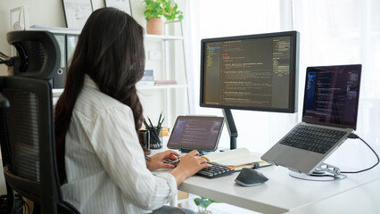 Focused female programmer coding at modern home office.