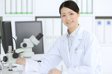 顕微鏡を見る白衣の女性