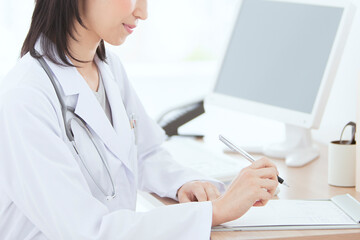 デスクに座る白衣の女性医師