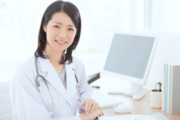 デスクに座る白衣の女性医師