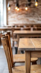 A cozy interior featuring wooden tables and chairs, illuminated by warm hanging lights, creating a welcoming atmosphere.