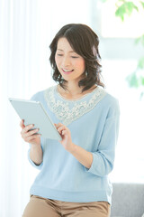 Fototapeta premium タブレットを操作する中年女性
