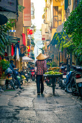 A fruit vendor pushes a bike in Hanoi, Vietnam