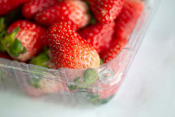 Strawberry in plastic box on white background and buy from supermarket. 