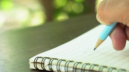 Man hand with pencil writing on notebook. focus on man hand holding pen