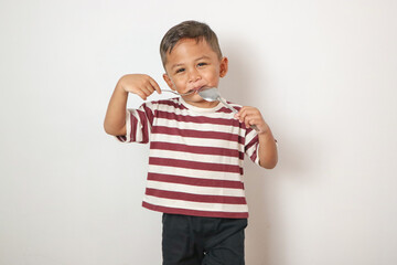 Naklejka premium Front view of a cute asian boy ready to eat with isolated white background.