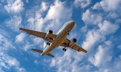 Obraz premium Airplane in flight against a partly cloudy sky