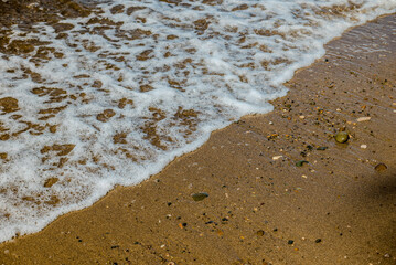 foam waves on the beach sand. Natural background