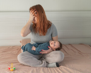 A woman holds a child in her arms and cries. Postpartum depression. 