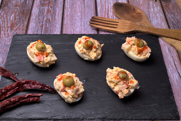 Stuffed eggs with olives on slate stone