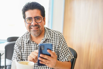 Latino Man Engaging in Online Sales at Cafe
