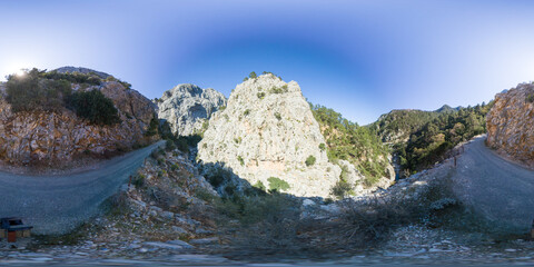 Seamless 360-Degree Panorama of a Winding Mountain Road Surrounded by Steep Cliffs and Green Valleys Leading to Goynuk Canyon in Turkey Under a Clear Blue Sky. Scenic Road and Outdoor Adventure
