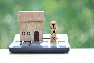 Estate tax,Model house on calculator with tax word on natural green background,Business investment and Property tax concept