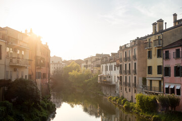 Afternoon summer sun over medieval old town landscape of Padova, Italy, with river Bacchiglione in...