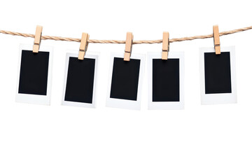 Empty polaroid photos hanging on clothesline isolated on white background with vintage nostalgic vibe