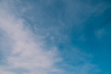 The beautiful blue sky, dotted with white clouds, glows under warm sunlight, painting a serene background that captures the peaceful essence of nature and weather.